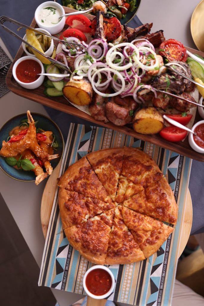 A delicious spread featuring grilled skewers with vegetables and a cheesy pizza, perfect for a hearty meal.