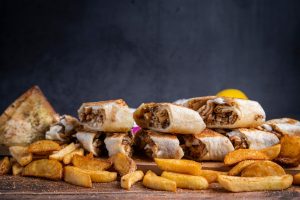 Delicious Middle Eastern wraps and seasoned potato fries. Perfect for casual dining or food photography.